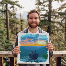 Load image into Gallery viewer, Custom art canvas wrap depicting a young couple sitting on a rock overlooking a mountain valley at sunrise. The custom art canvas wrap is being held by the smiling man in the original personal photo used to make the custom art work.